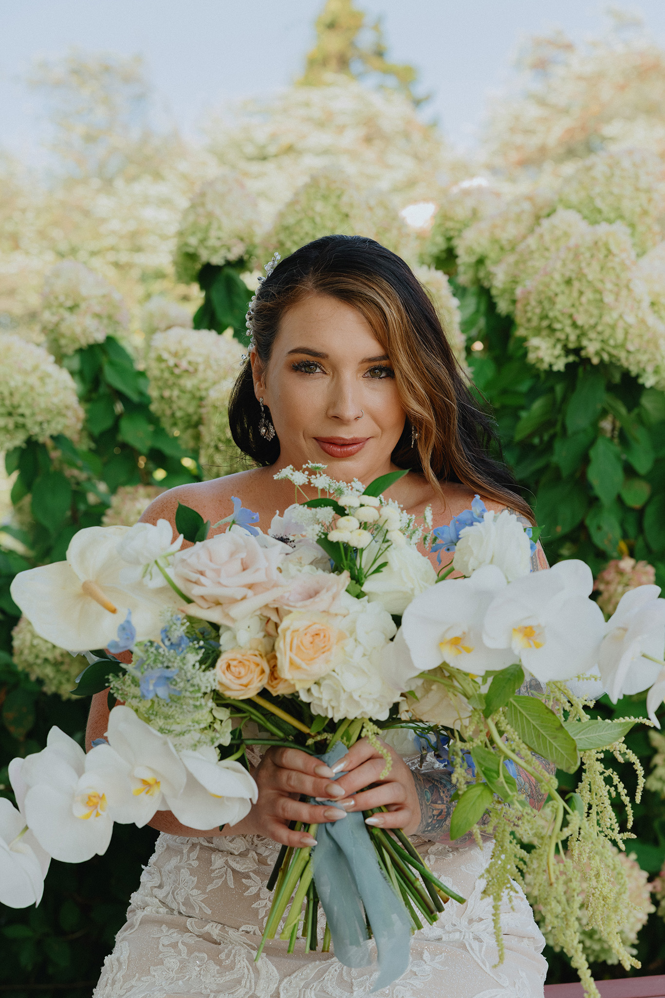 Portrait of a smiling bride holding her bouquet in a Boston garden